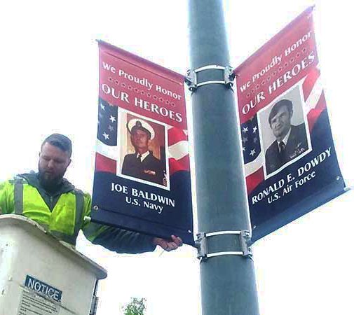 two banners that says "we proudly honor our heroes"